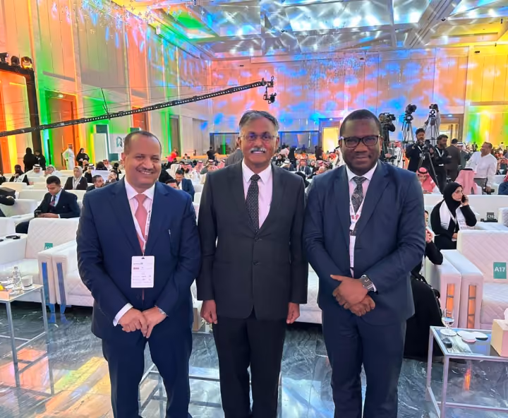 Dr. Emad Hussein attending a conference with fellow professionals in a brightly lit event hall.