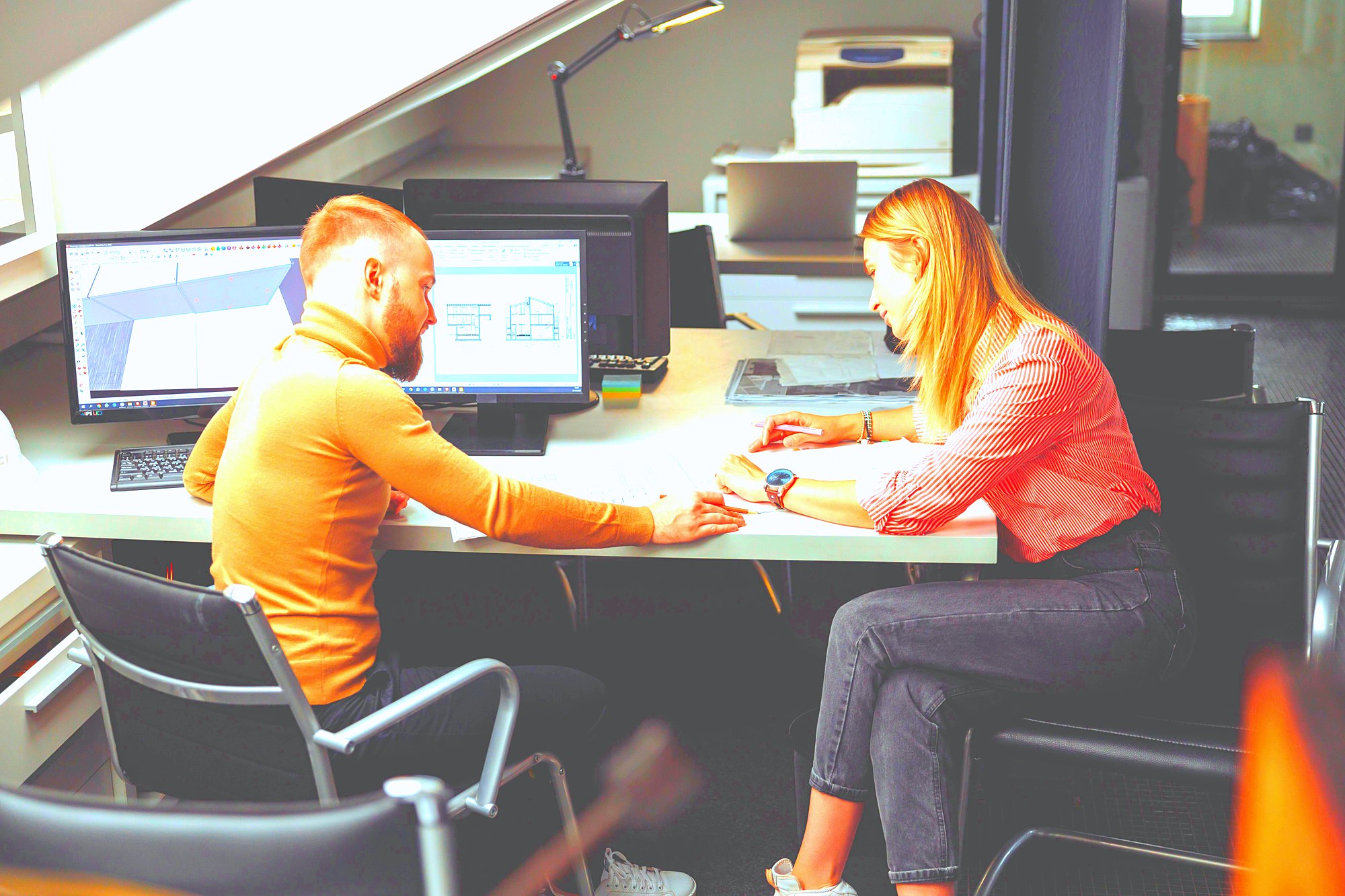 Two professionals reviewing documents together in a meeting