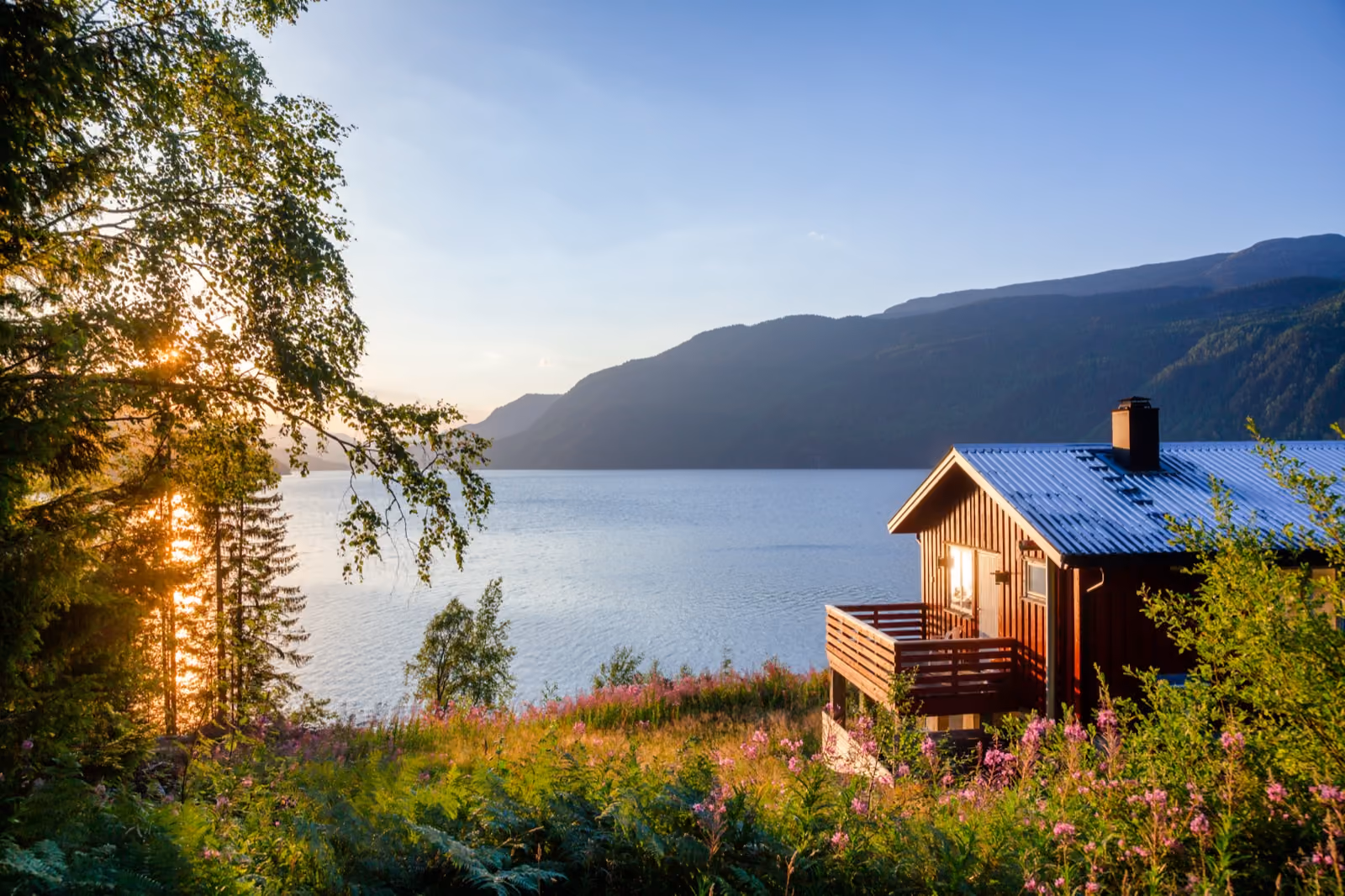 Hytte med utsikt over fjorden i solnedgang