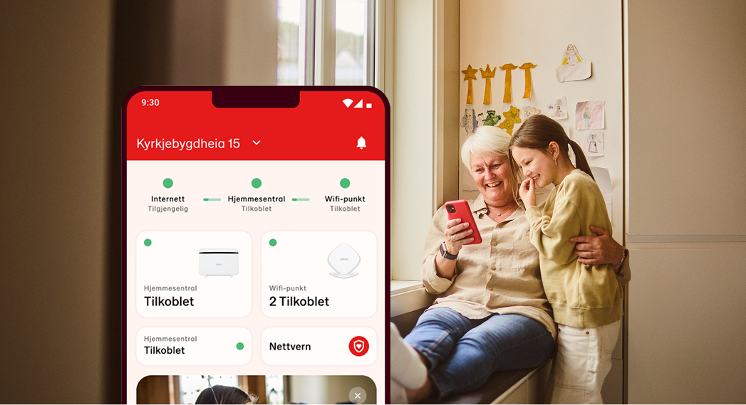 Bestemor og barnebarn ser på Altibox Hjem-appen sammen i en lys stue