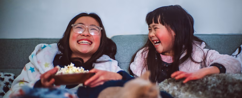 Familie som ser på TV sammen med popkorn og snacks