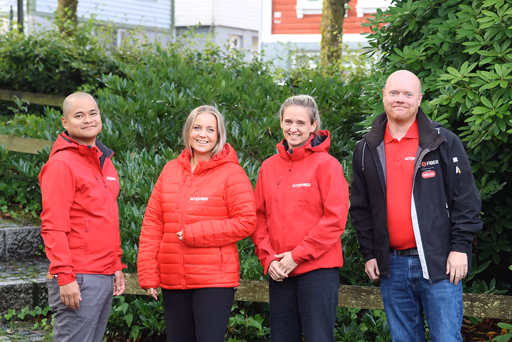 Altifiber-ansatt i svart genser fotografert på en gressplen