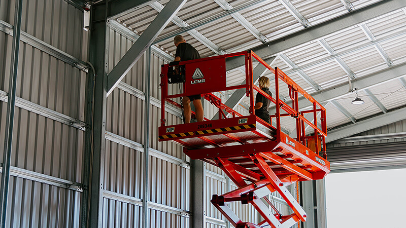 Carve electricians installing wiring in large shed