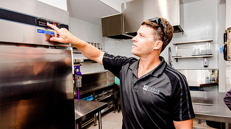 Refrigeration expert tests fridge in commercial kitchen