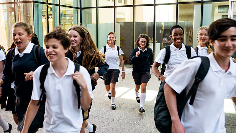 Smiling children leaving school at end of day