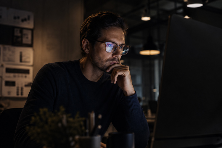 A man at a computer at night demonstrating ZEISS Progressive Lenses