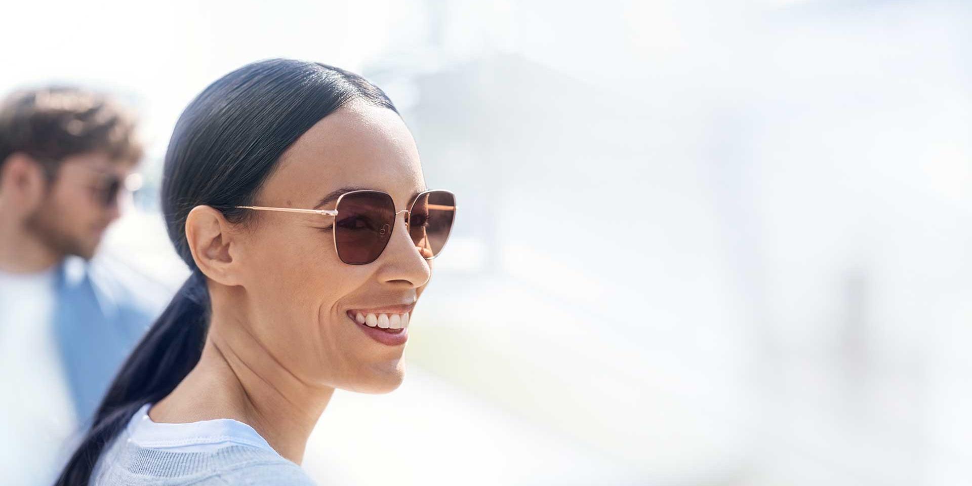 A happy woman wearing ZEISS PhotoFusion lenses