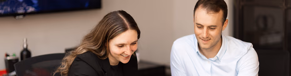 Two colleagues reviewing work together in a meeting room