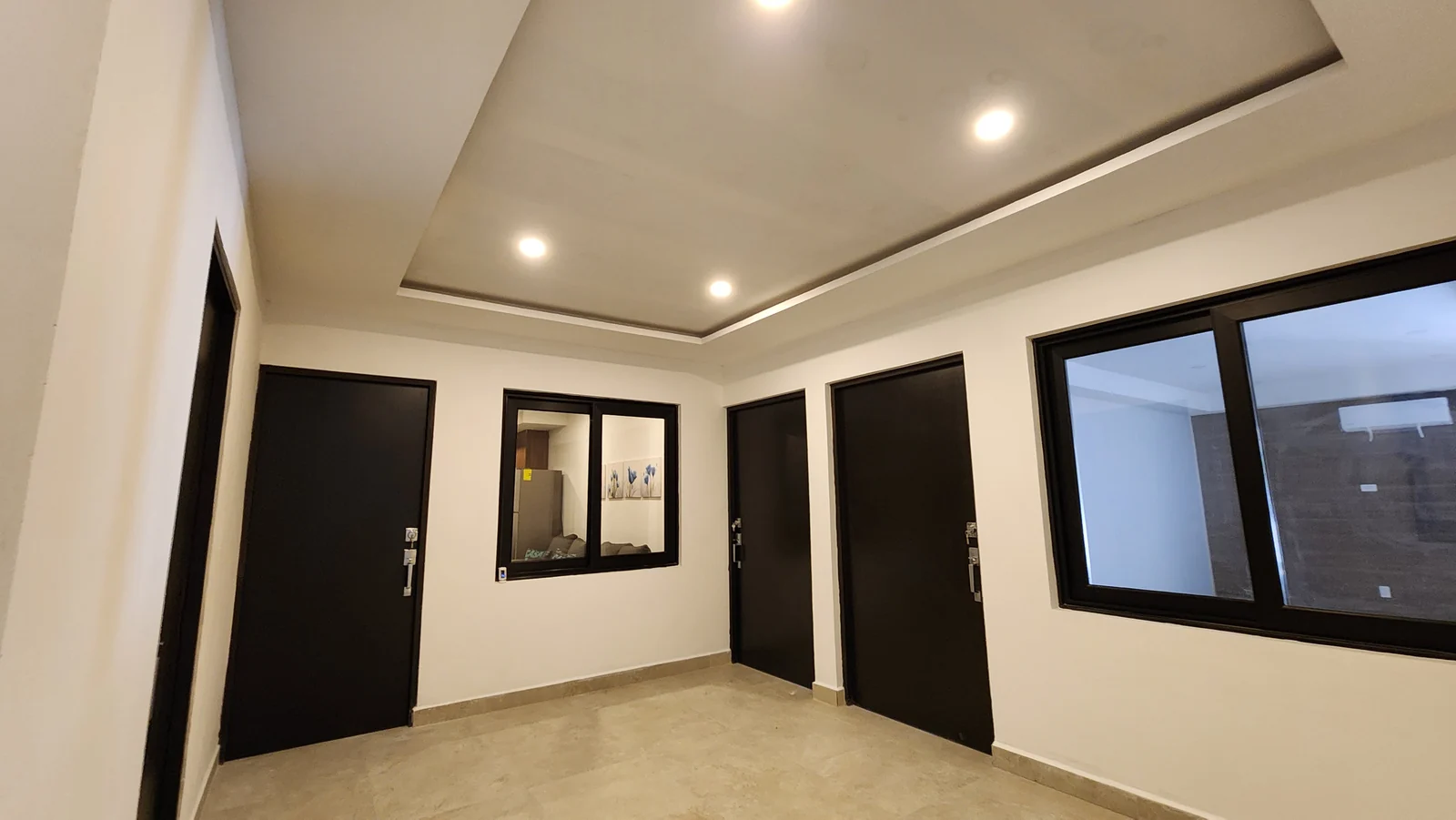 Interior common area with doors and ceiling lighting at Quince Sur