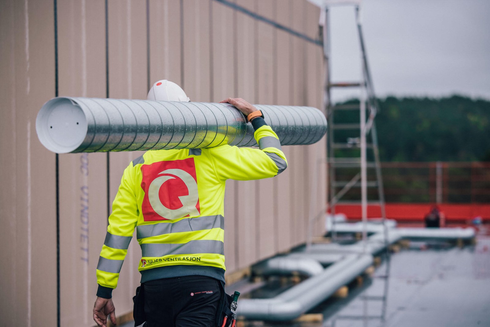 Montør fra Agder Ventilasjon bærer en ventilasjonskanal
