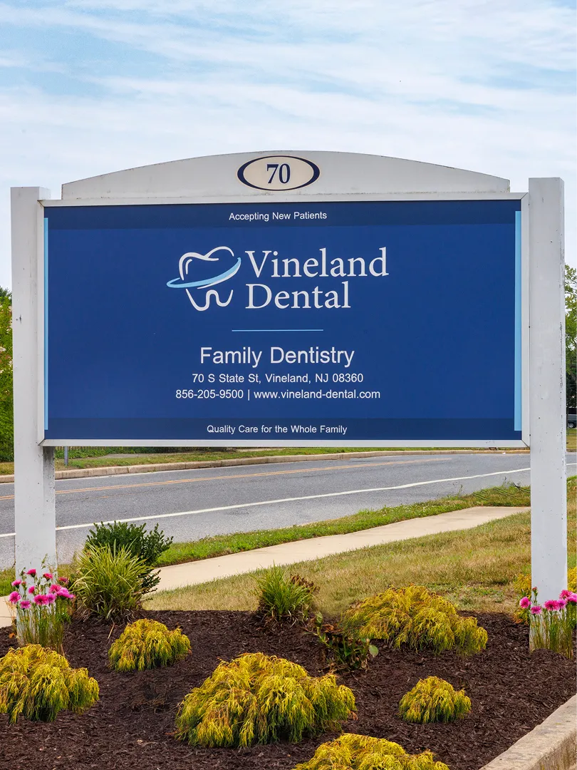 Vineland Dental sign for family dentistry with address, phone number, and website on roadside.