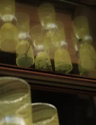 Several yellow candles inside glass holders arranged on shelves with a warm glowing ambiance.