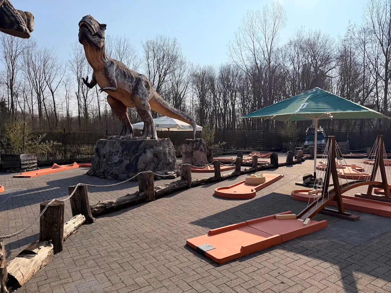 Dinosaure et pistes du parcours de mini golf extérieur de Laser Magic