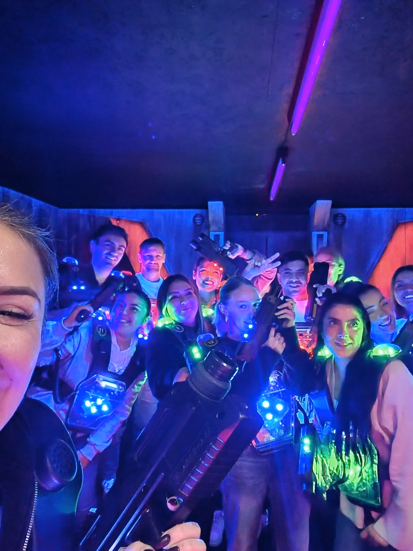 Selfie d'un groupe d'adultes équipés de gilets laser dans l'arène