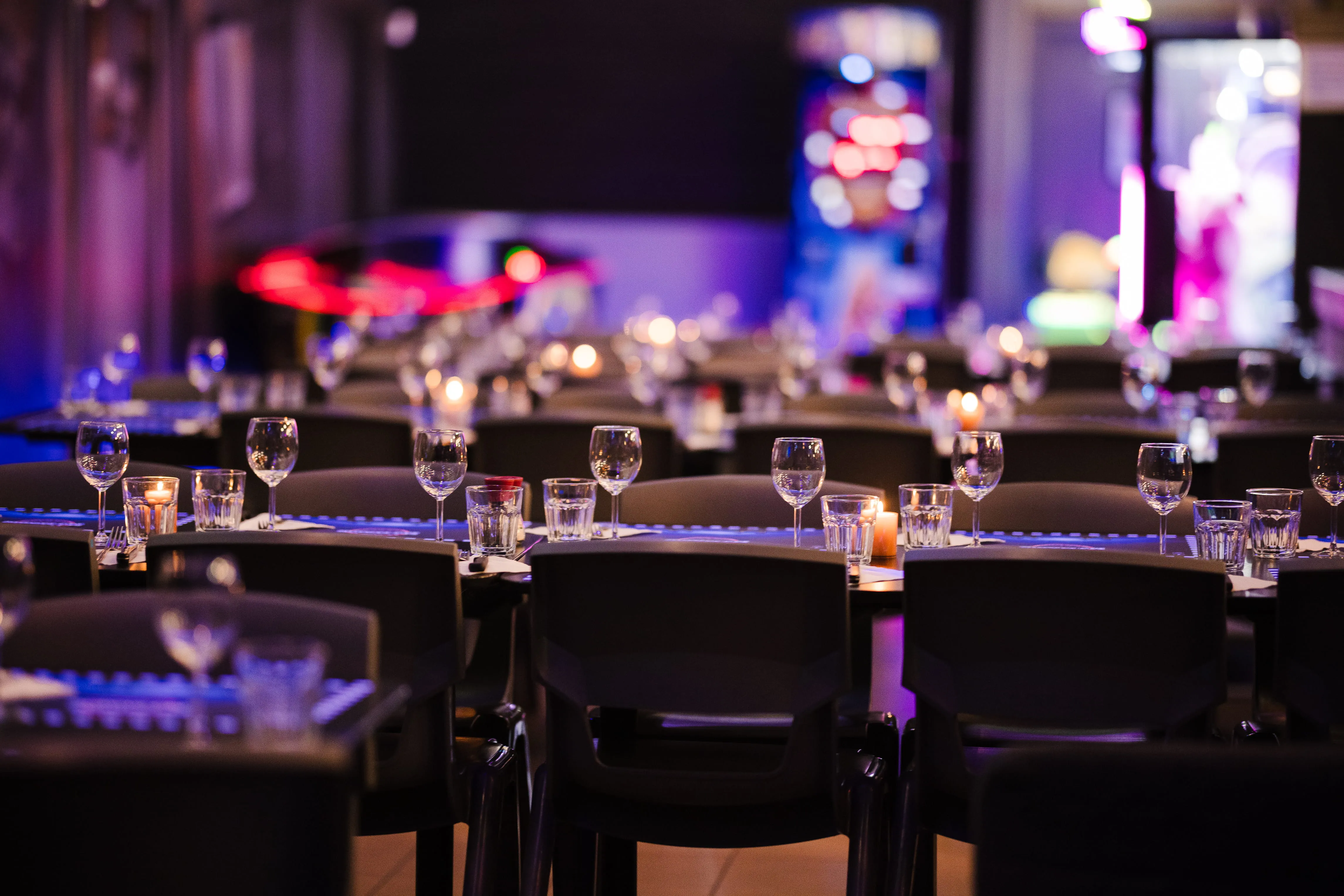 Tables dressées pour un repas de groupe, ambiance tamisée