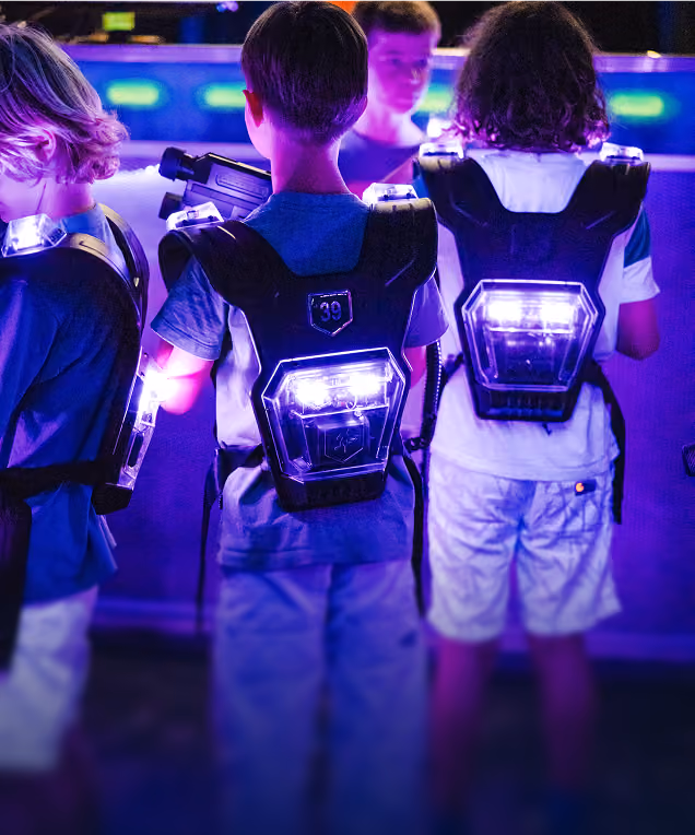 Enfants de dos, gilets de laser game allumés