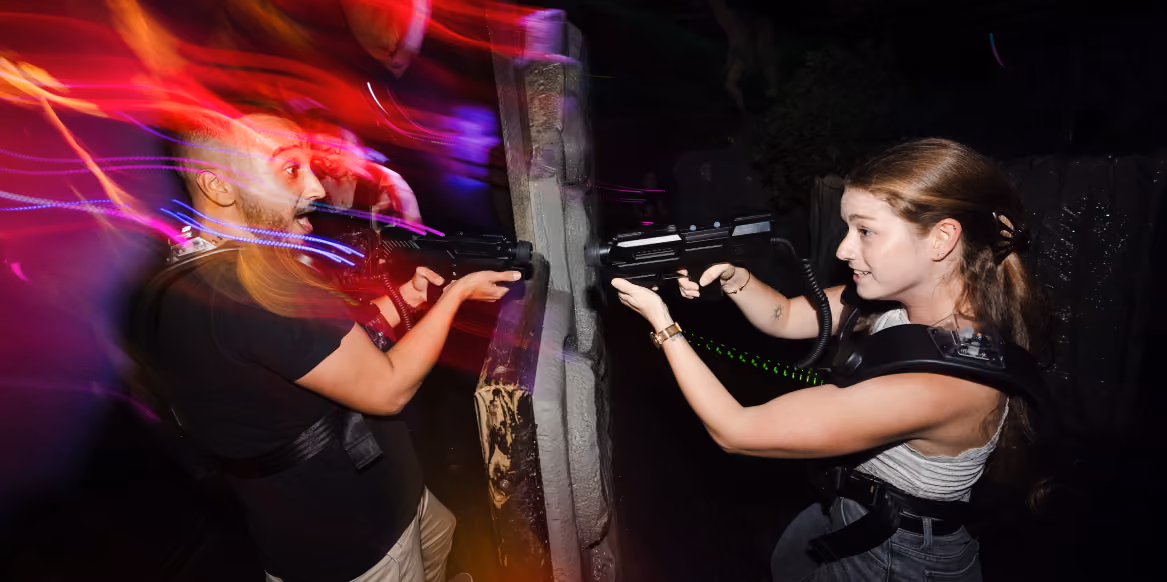 Deux joueurs visant derrière un obstacle en arène de laser game