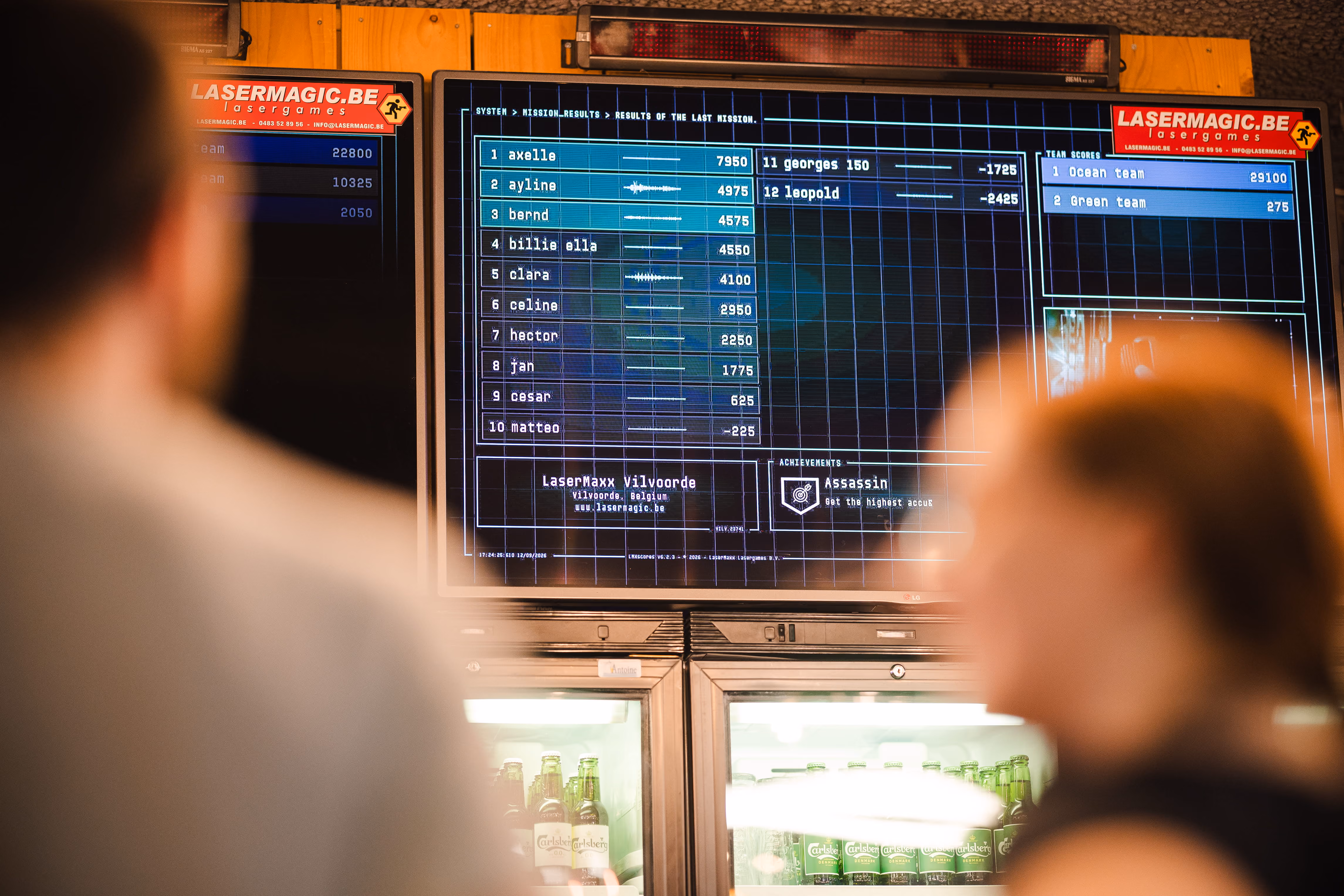 Écran des scores au-dessus des frigos à boissons de l'accueil
