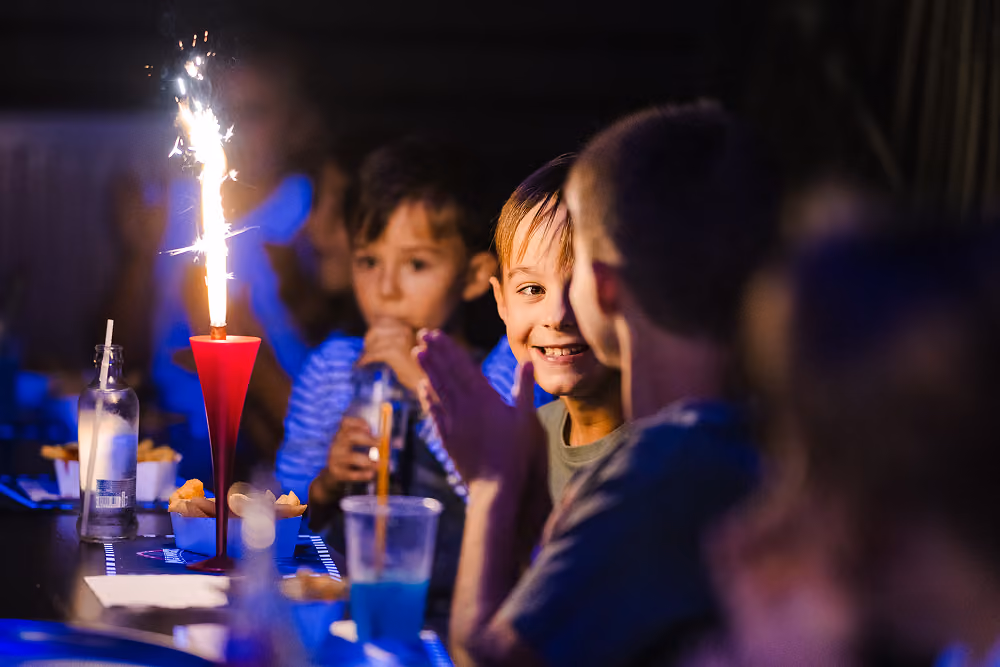 Enfants à table autour d'un cierge magique d'anniversaire