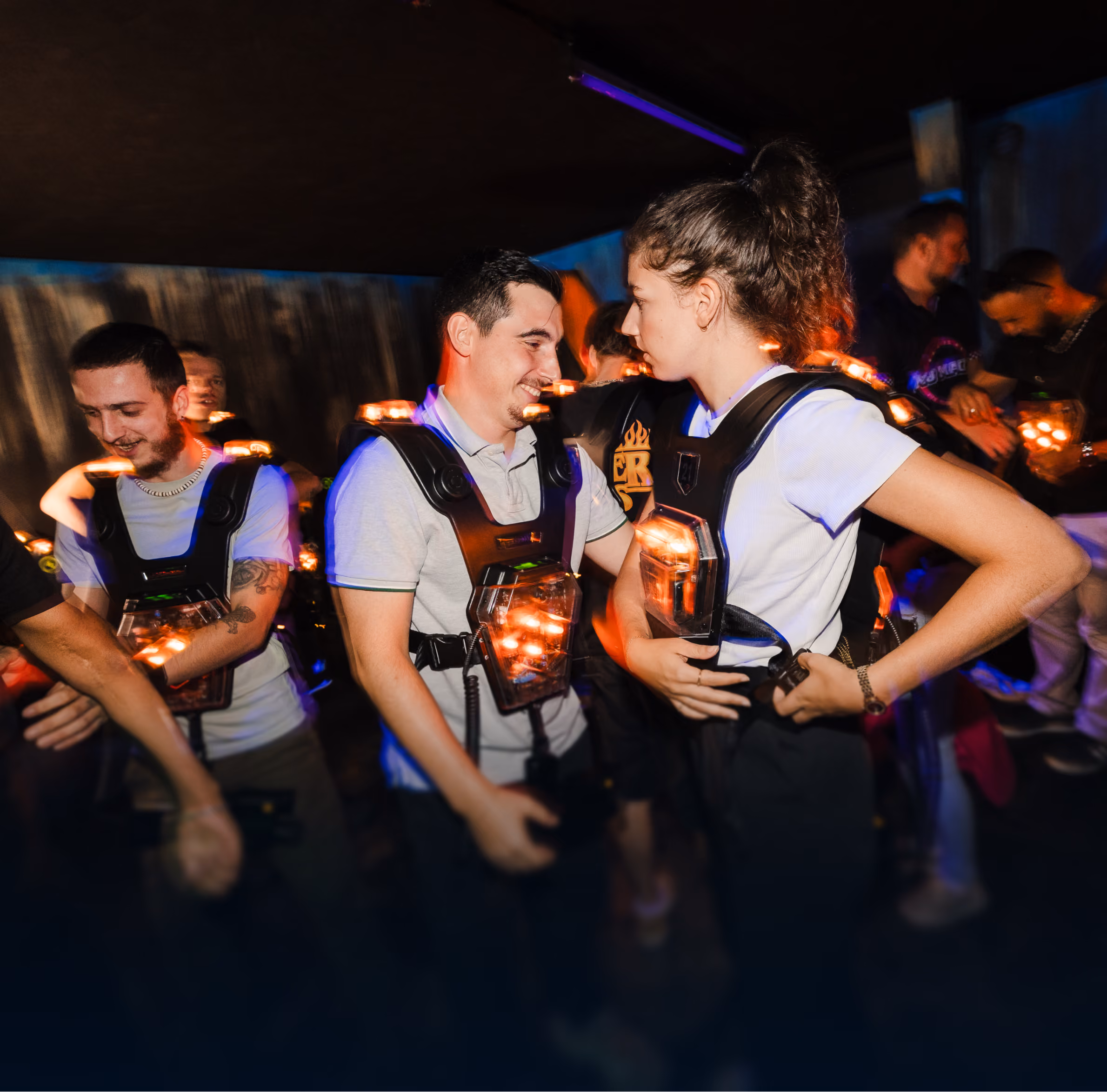 Groupe de jeunes adultes en gilets laser riant avant la partie