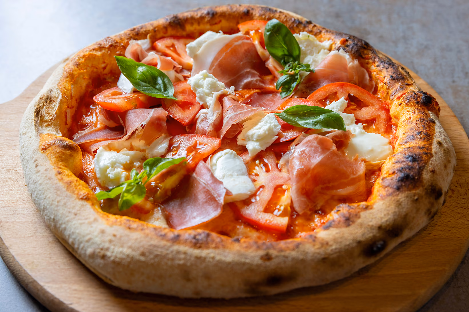 Pizza au jambon cru, mozzarella et basilic