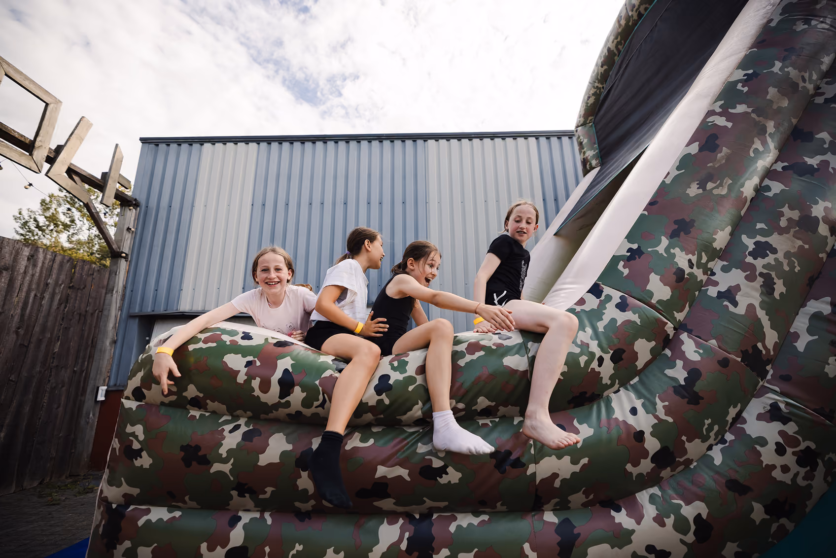 Adolescents sur une structure gonflable au motif camouflage