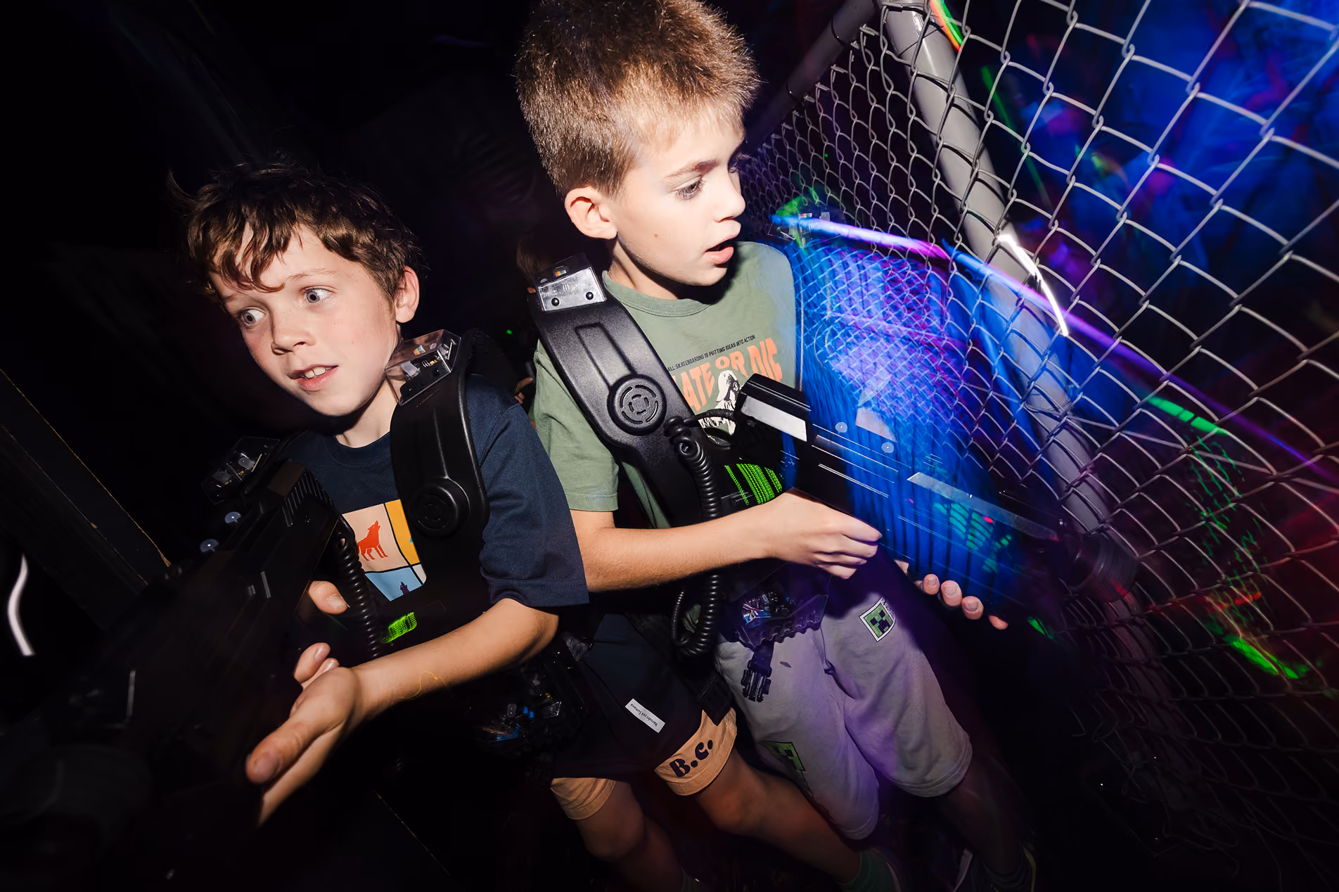 Deux enfants équipés en pleine partie de laser game