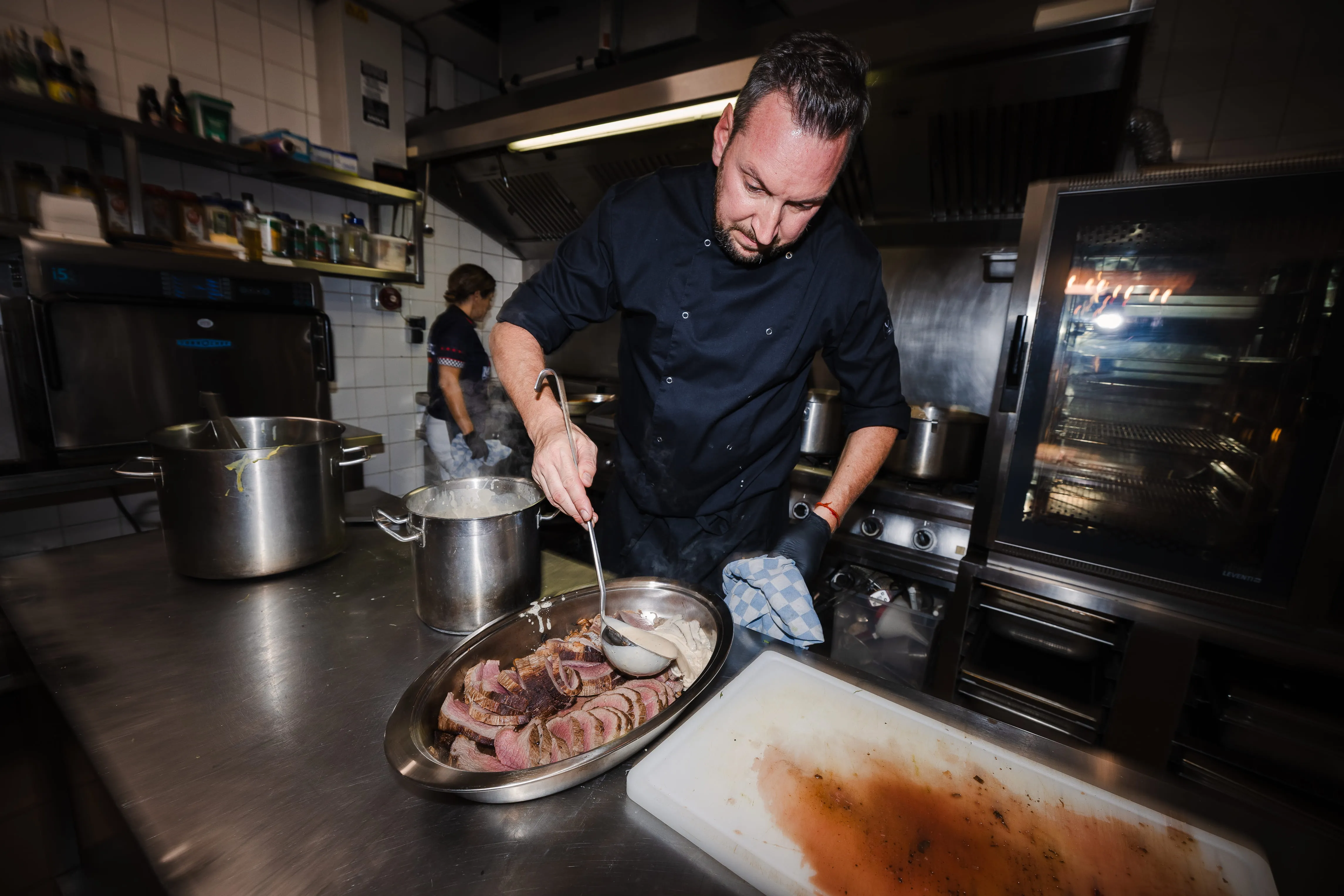 Chef découpant la viande dans la cuisine de Laser Magic