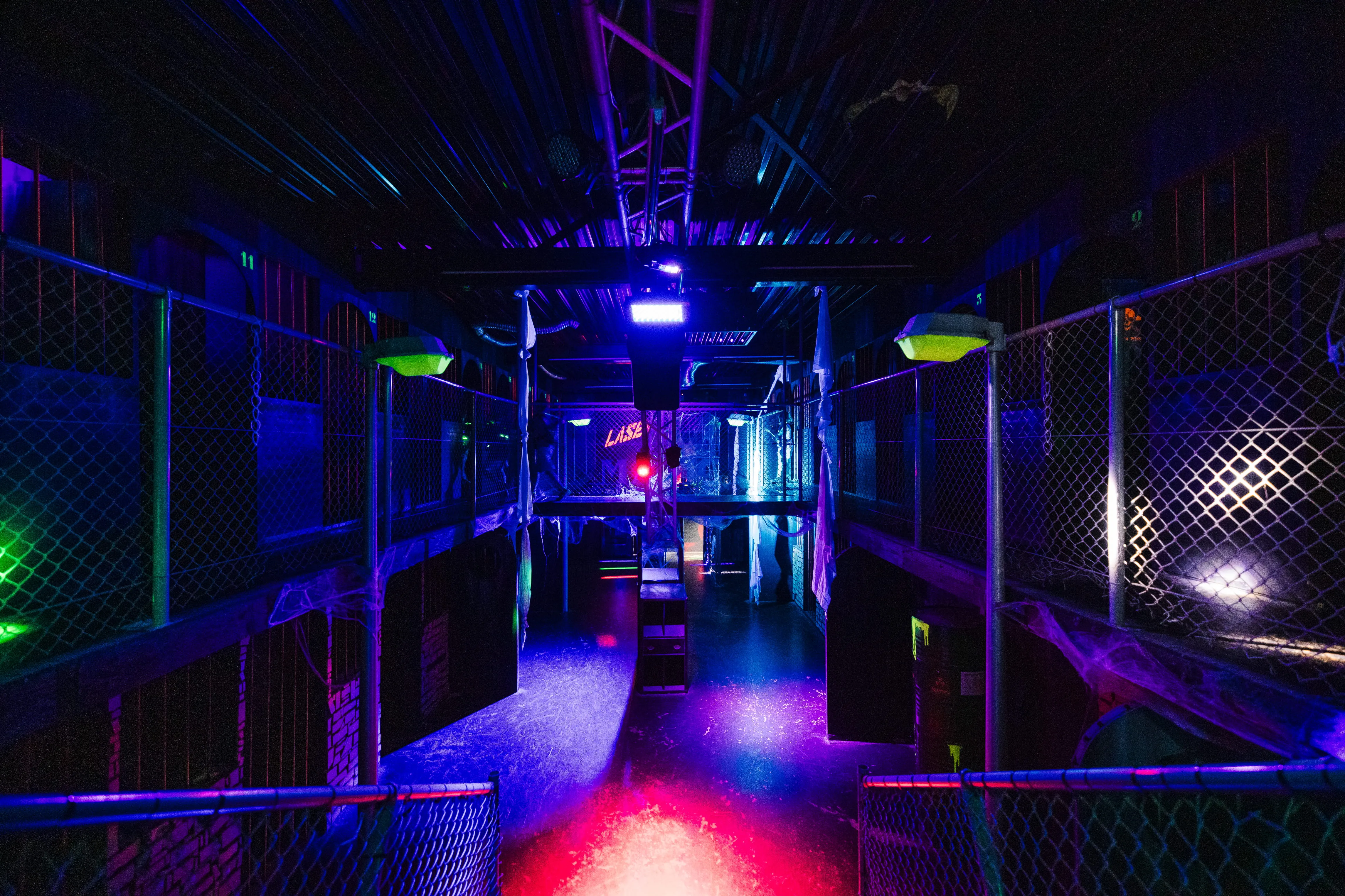 Arène de laser game à étages, grillages éclairés en bleu et rouge