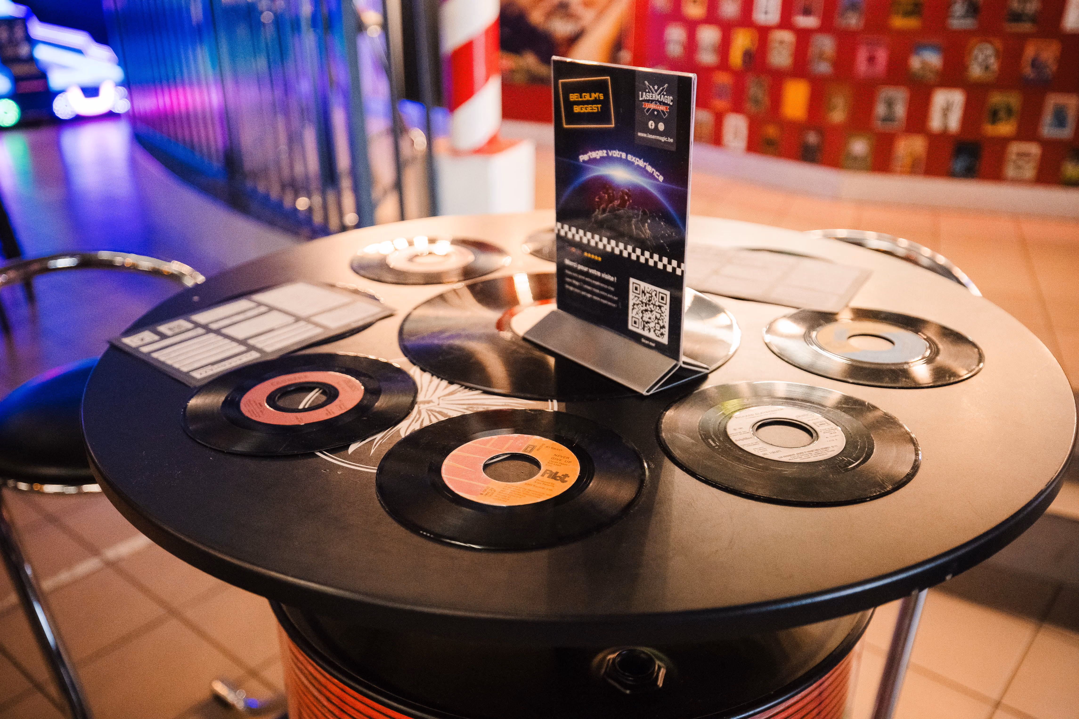 Table haute décorée de disques vinyles dans l'espace bar de Laser Magic