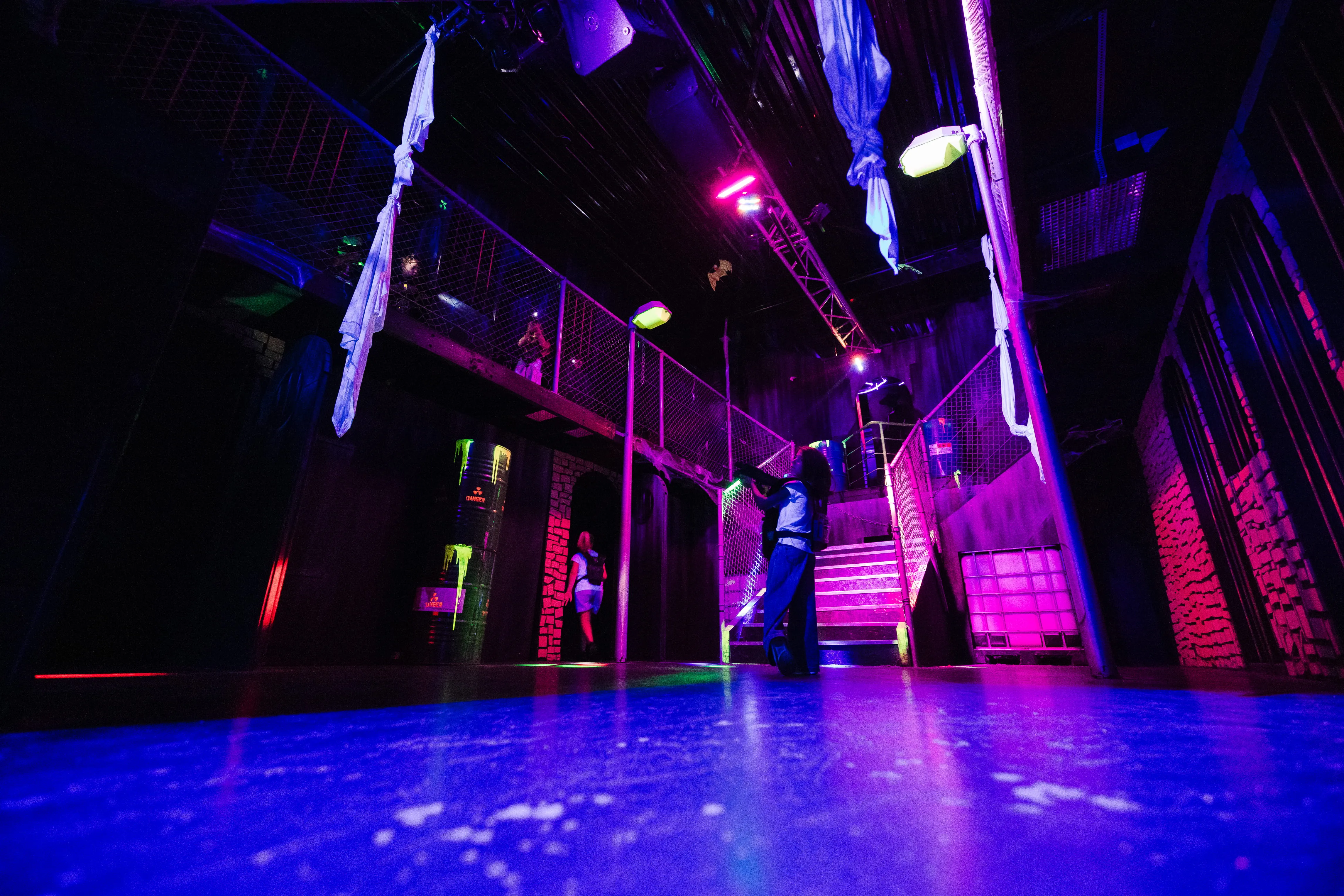 Arène de laser game éclairée en violet, passerelles en hauteur