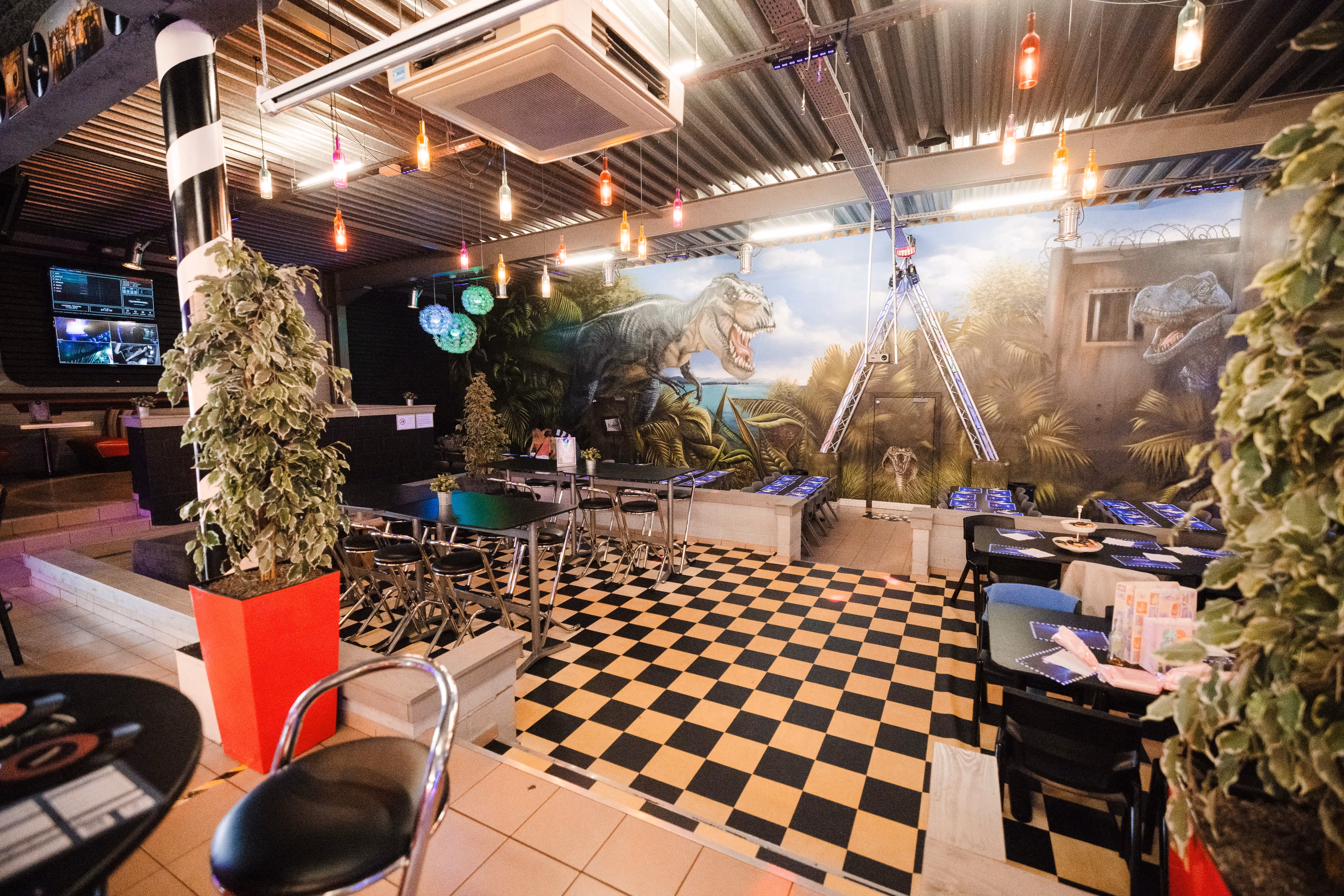 Salle de restaurant au décor jungle et sol en damier