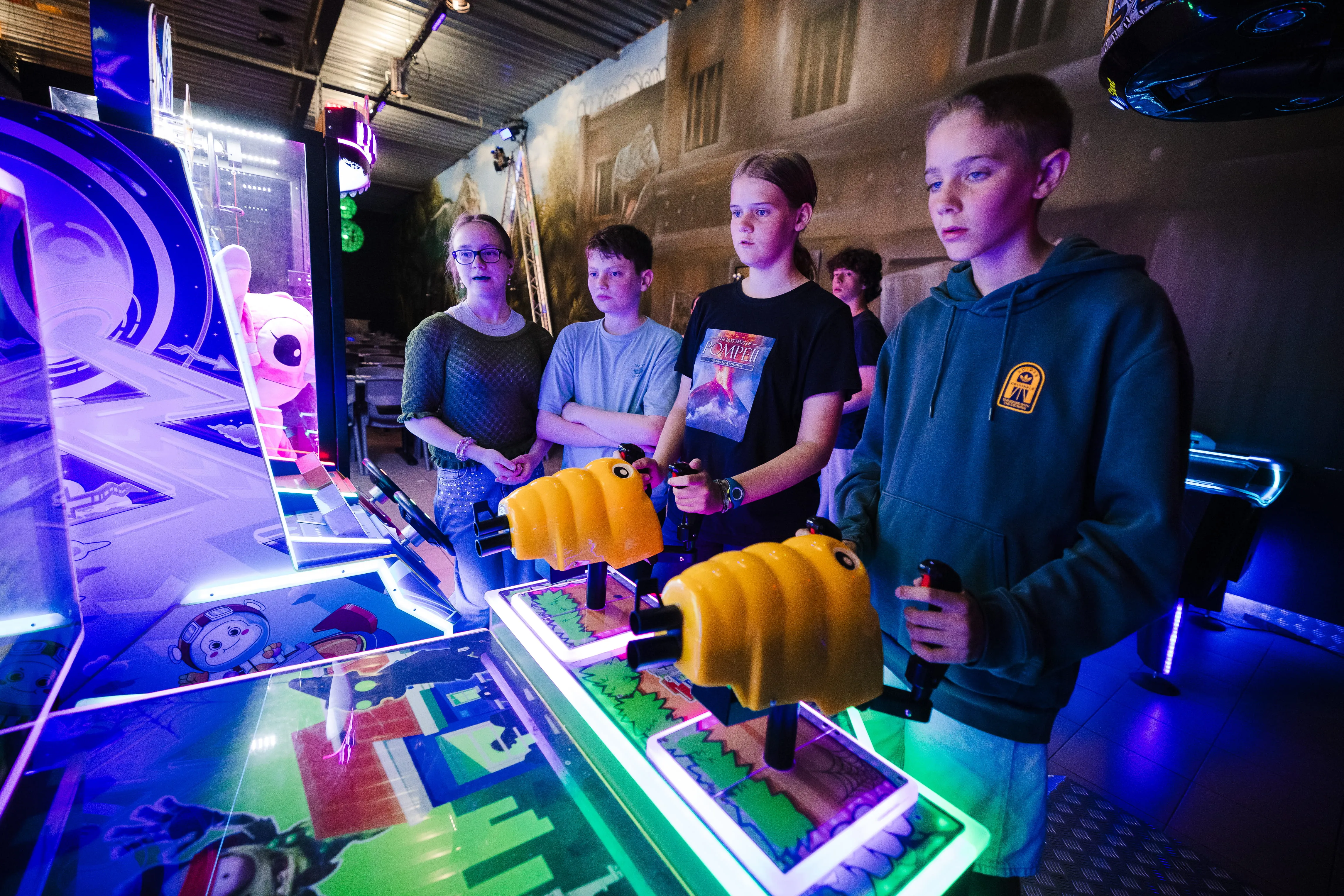 Adolescents jouant ensemble sur une borne d'arcade