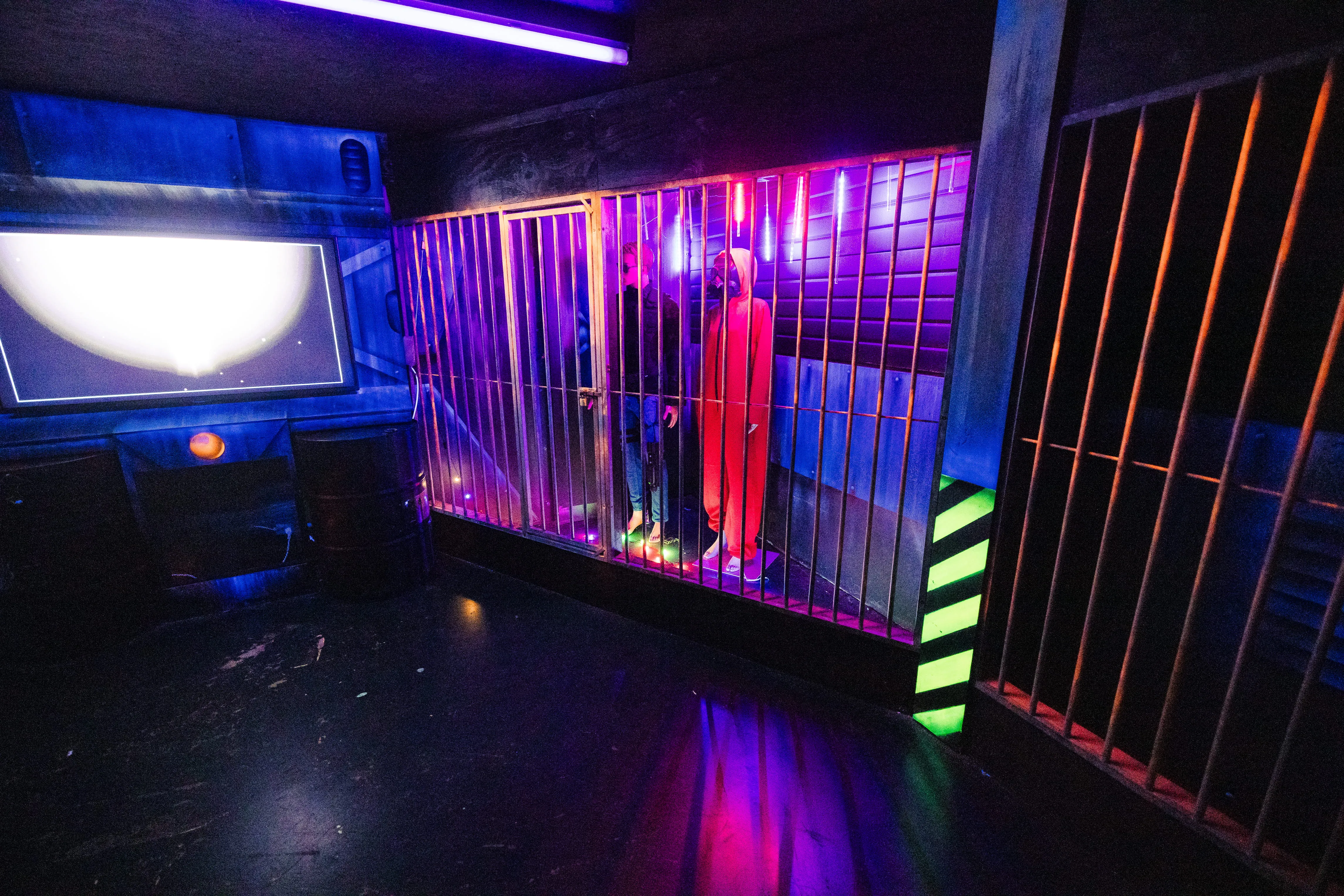 Cellules grillagées sous éclairage violet dans une arène de laser game