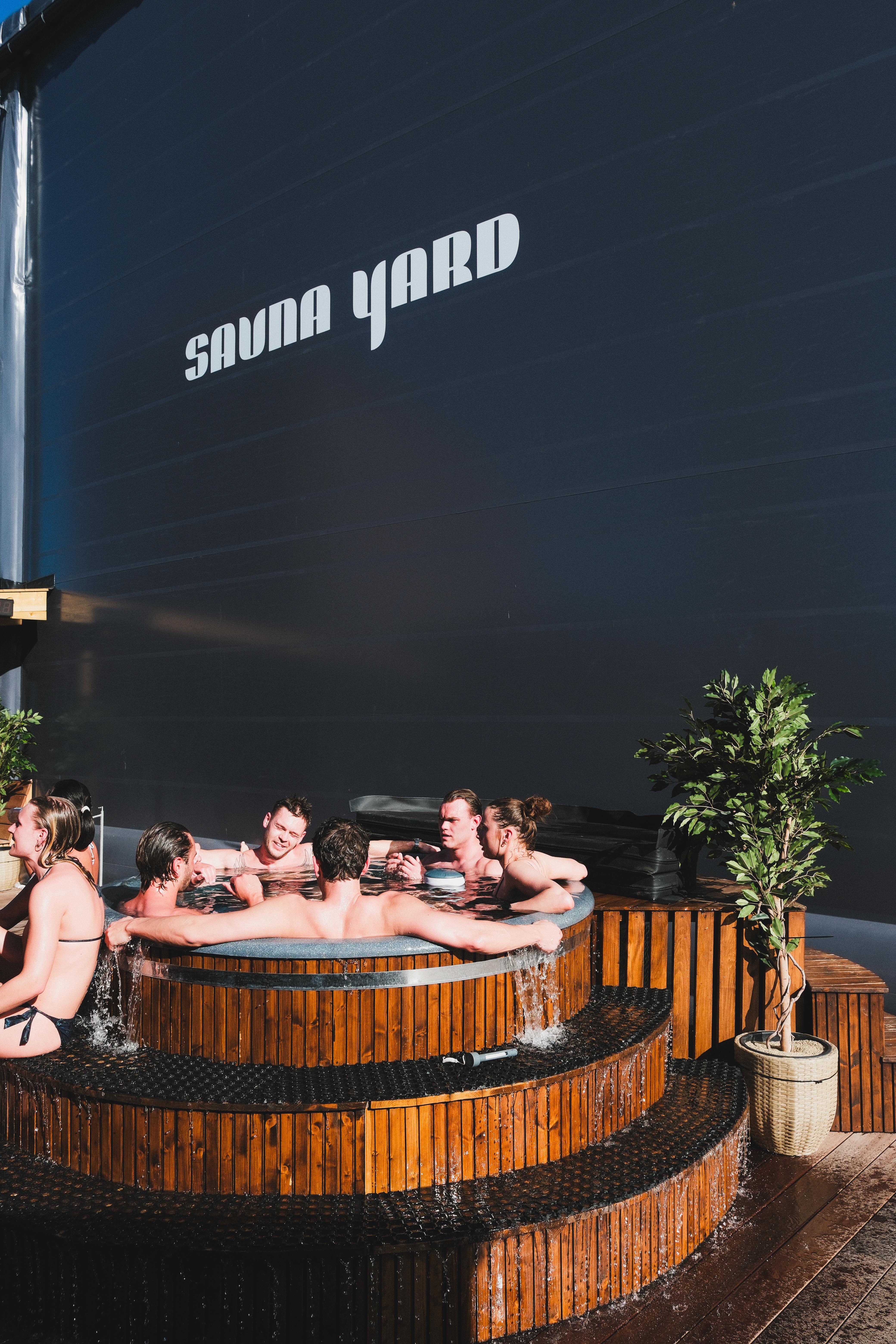Gæster samlet i det udendørs bad ved Sauna Yard