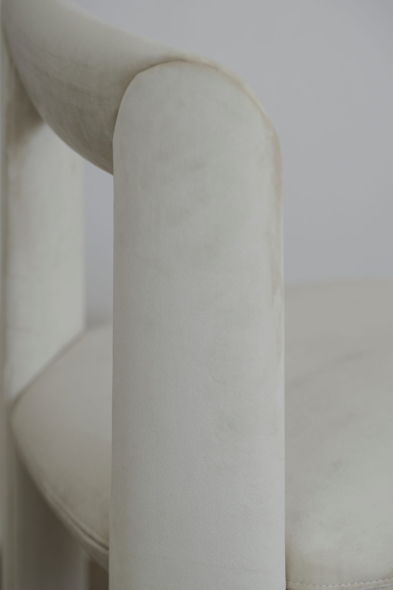 Detail der umlaufenden Rückenlehne des Amia Stuhls in Creme