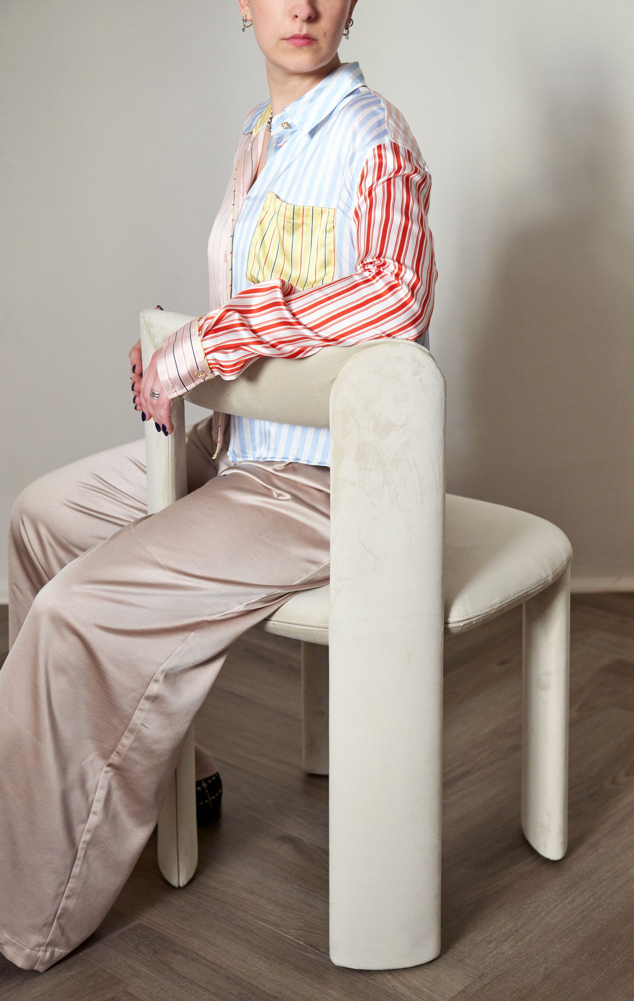 Amia Stuhl in Creme in einer Wohnszene mit sitzender Person