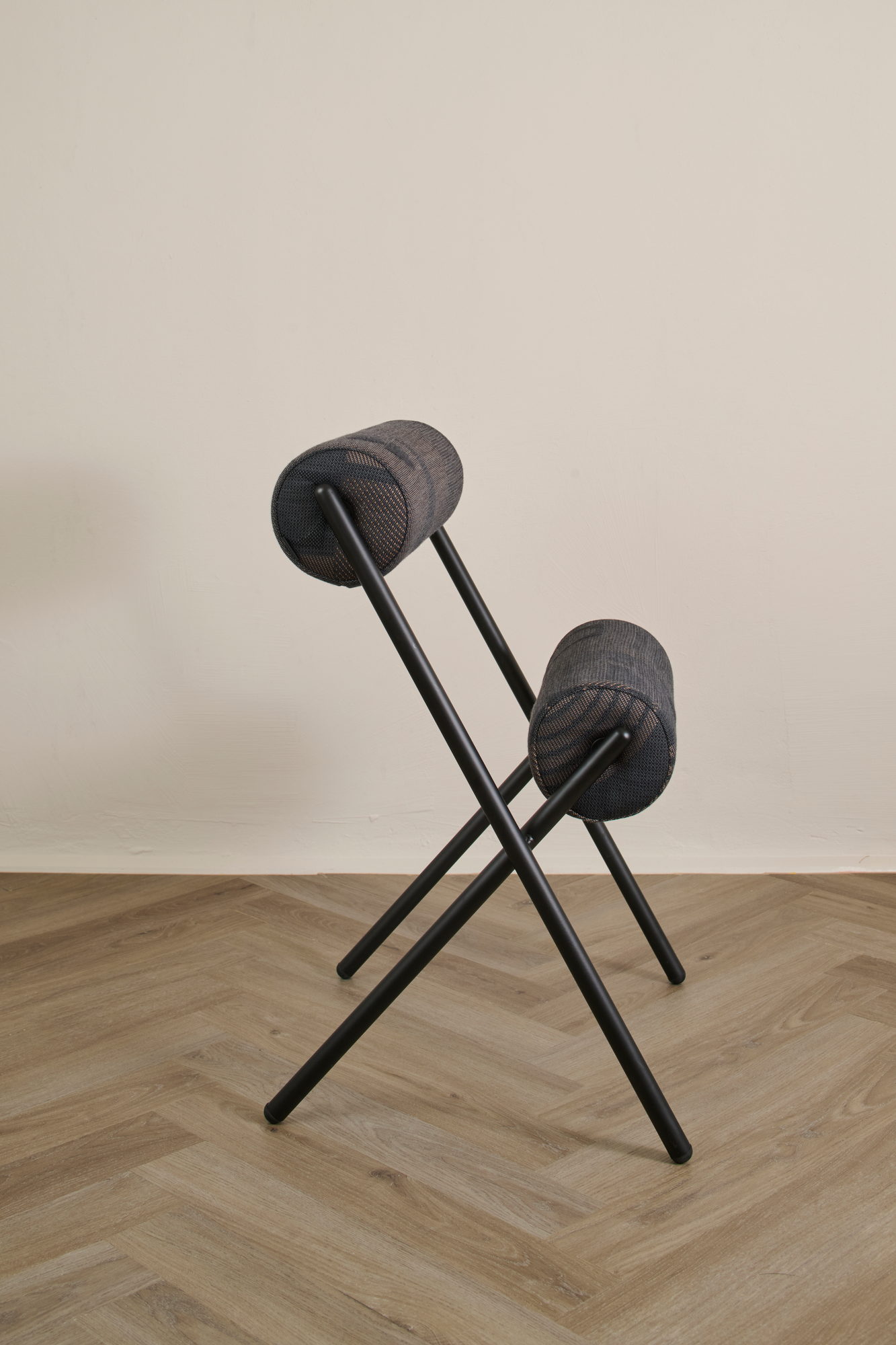 Roll Chair in Dunkel von der Seite mit gekreuztem Stahlgestell