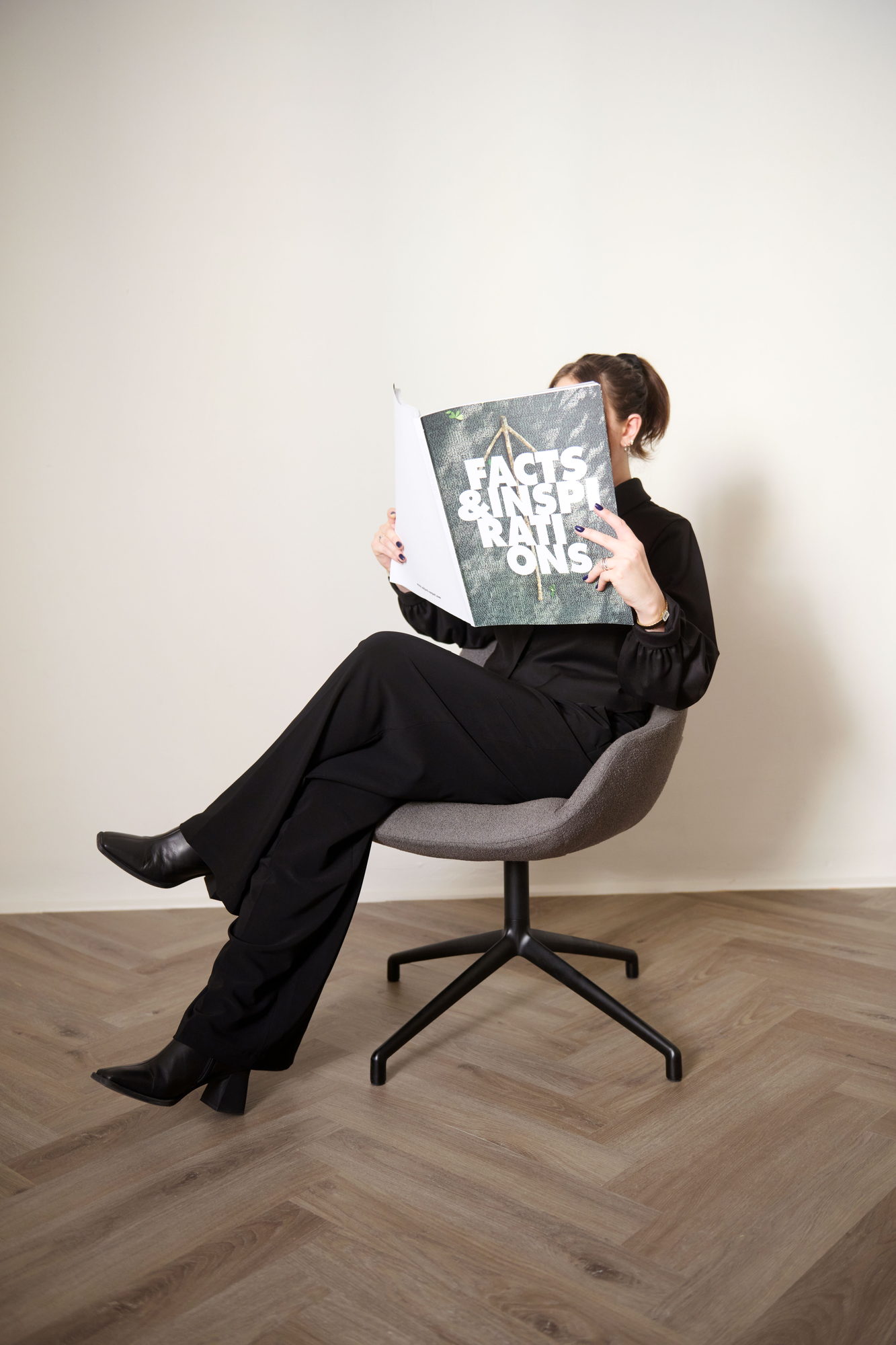 Sinum Armchair in Graubraun in einer Wohnszene mit lesender Person