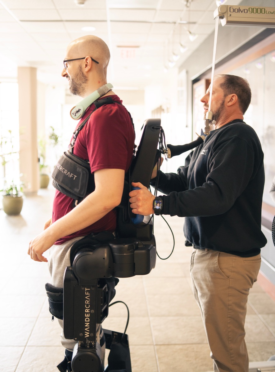 An engineer fitting a Wandercraft exoskeleton to a user