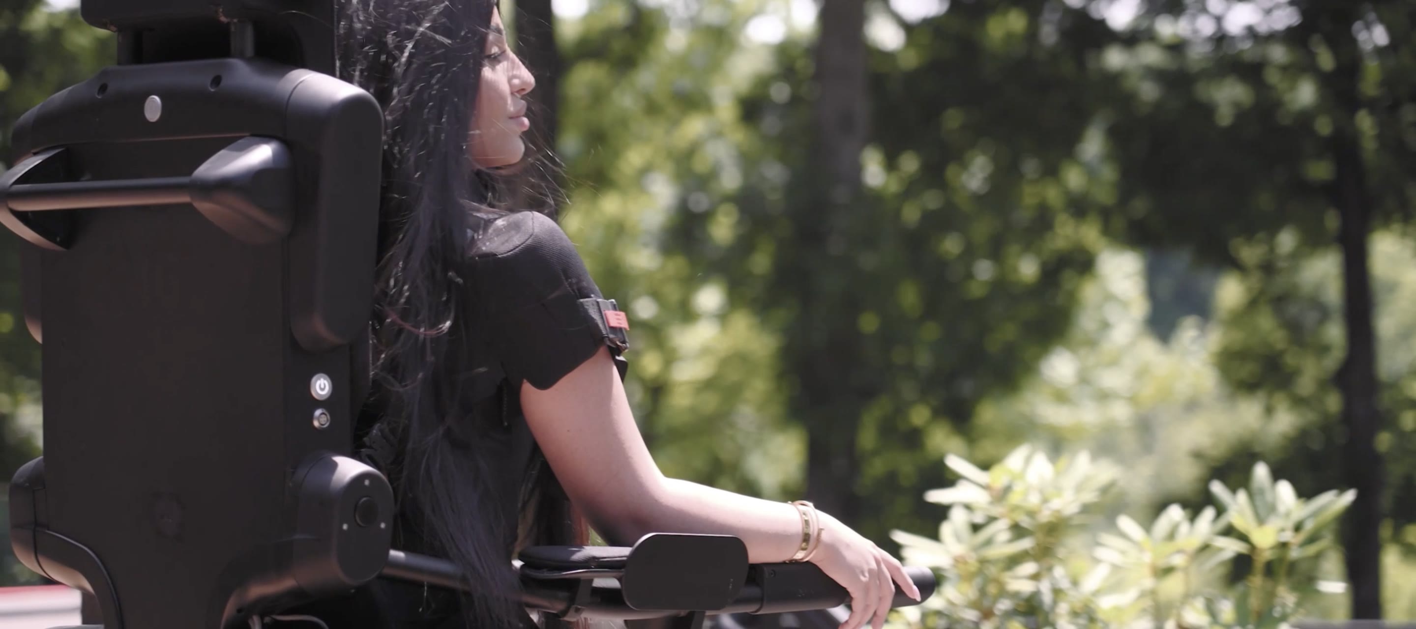 A man steadying a smiling young woman as she stands in the Eve personal exoskeleton