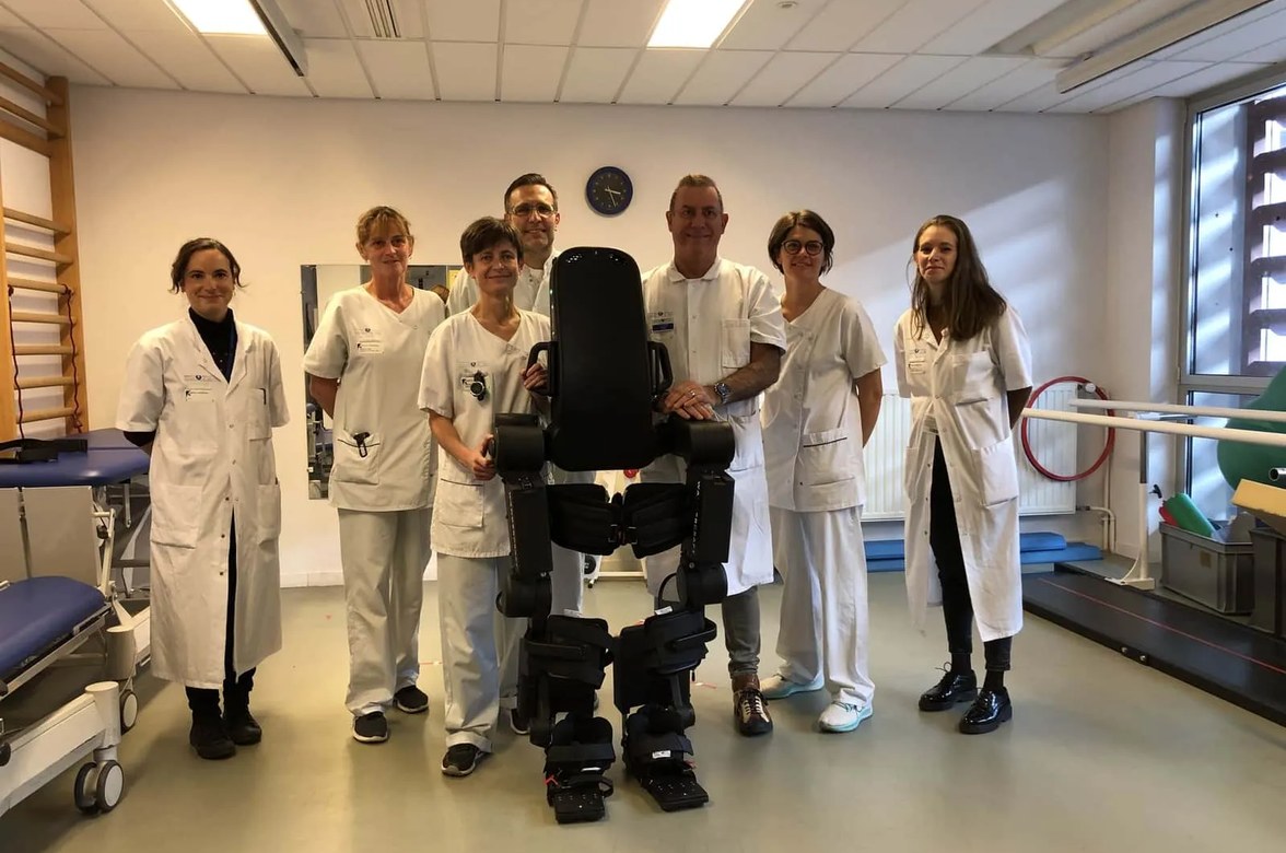 A hospital rehabilitation team standing with Atalante in their clinic