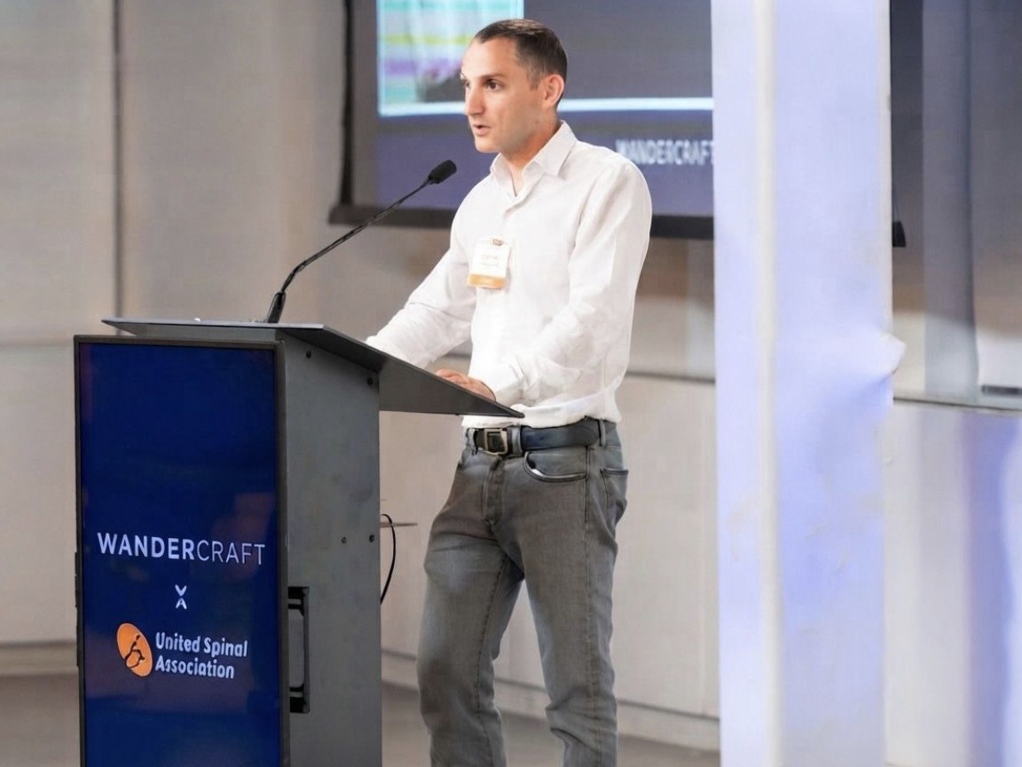 A Wandercraft speaker at the Eve launch event, at a lectern branded Wandercraft and United Spinal Association