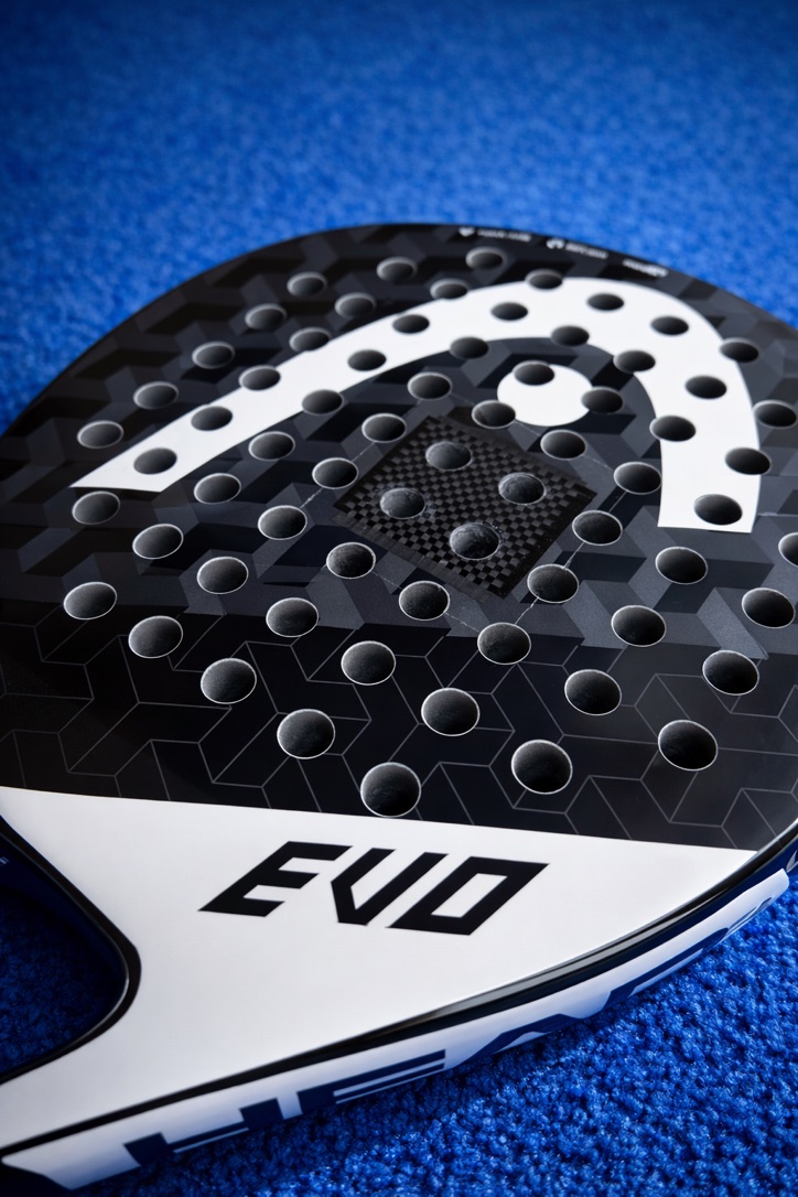 Close-up van een zwart-wit HEAD Evo padelracket op een blauwe padelbaan