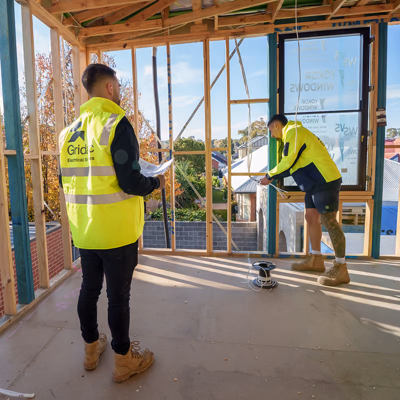 Two electricians working on site
