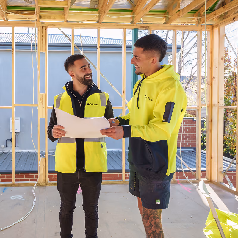 Two electricians looking at paperwork