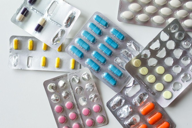 An assortment of pill and capsule blister packs in different colors and shapes arranged on a table