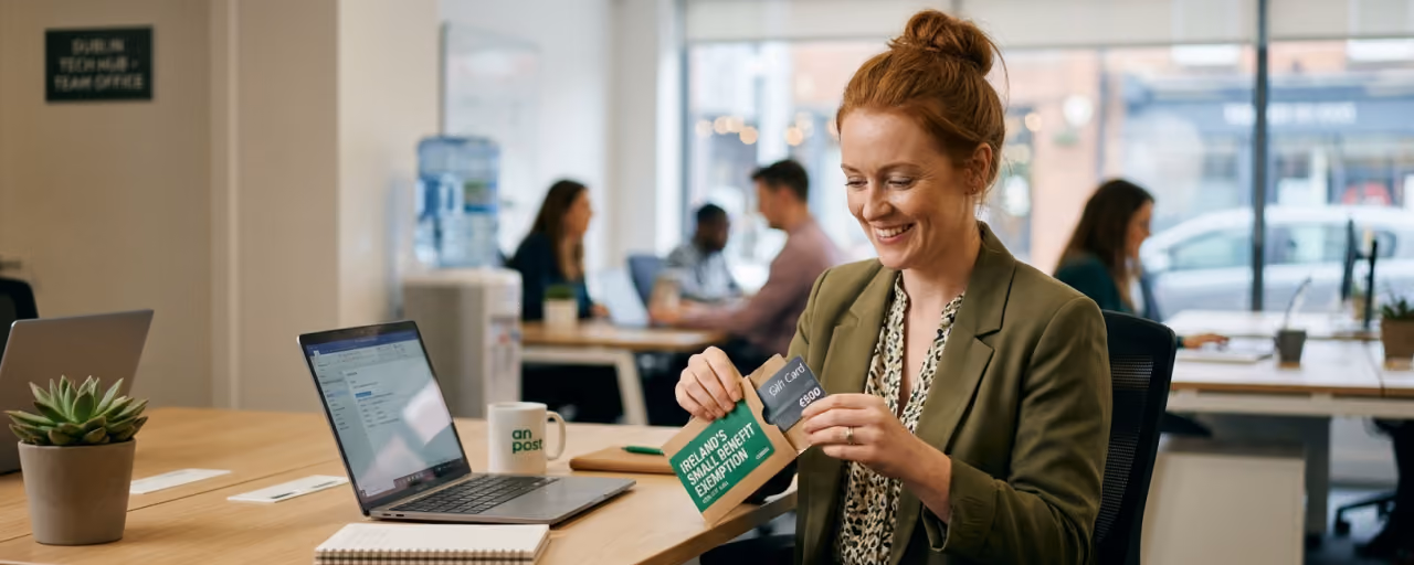 An employee unwrapping a gift card at work, representing Ireland's Small Benefit Exemption