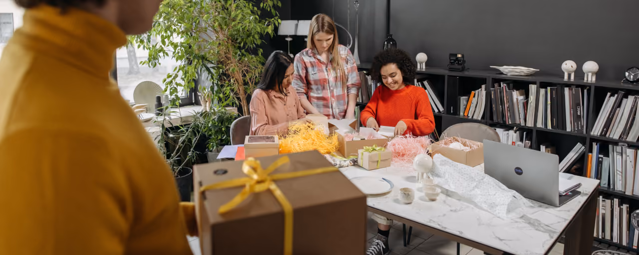 Office team preparing wrapped gift boxes for staff and clients