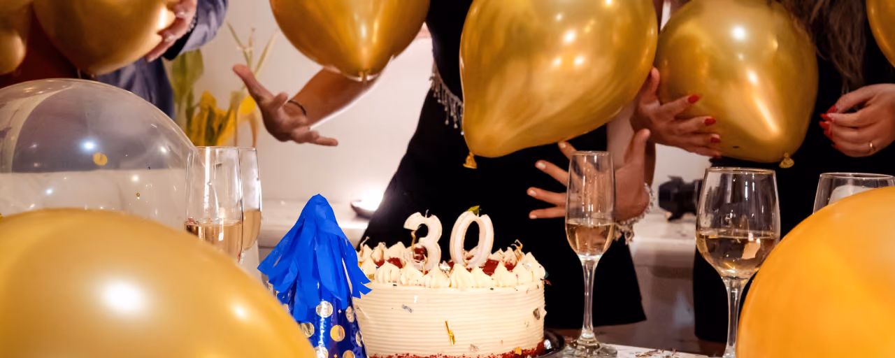 Friends raising champagne glasses around a 30th birthday cake